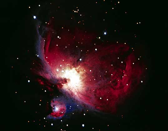БОЛЬШАЯ ТУМАННОСТЬ В ОРИОНЕ, сфотографированная в инфракрасных лучах. Эта туманность видна невооруженным глазом в Мече Ориона. Она состоит из газа и пылевых частиц, которые освещаются звездой q Ориона, погруженной в туманность.