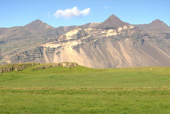 Зелёные поля у скал Исландии. Стоккнесс.